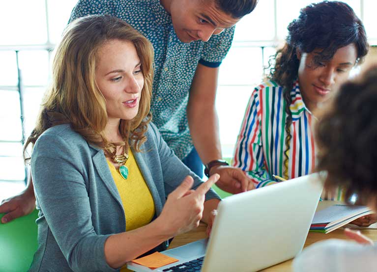 Young adults grouped around a computer. - 767x554.jpg